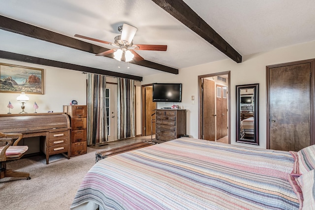 carpeted bedroom featuring beamed ceiling and a ceiling fan