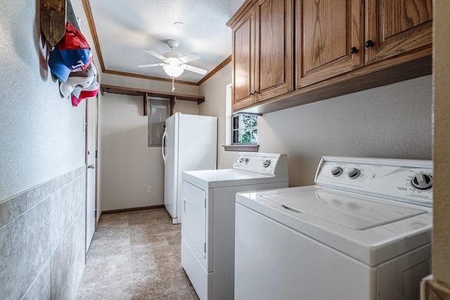 washroom featuring ornamental molding, stone finish floor, washer and clothes dryer, a ceiling fan, and cabinet space