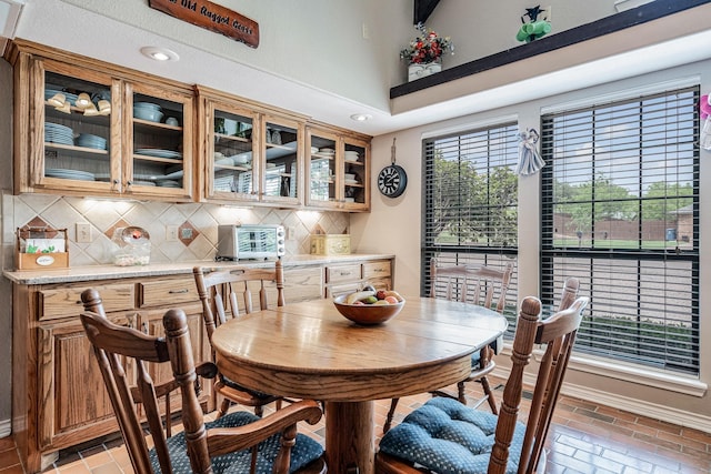 dining space featuring baseboards, recessed lighting, brick floor, and a toaster
