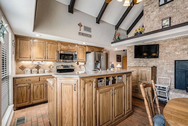 kitchen with appliances with stainless steel finishes, brick floor, decorative backsplash, and visible vents
