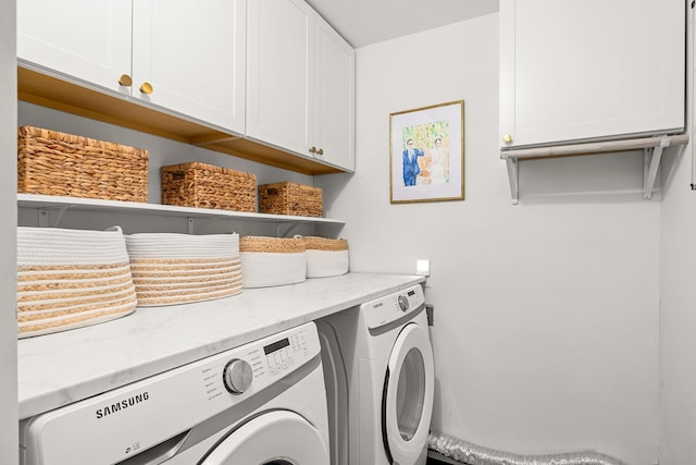 laundry room with washer and clothes dryer and cabinet space