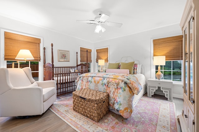 bedroom featuring crown molding, ceiling fan, and wood finished floors