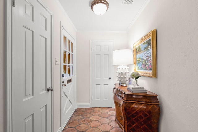 foyer entrance with crown molding, baseboards, and visible vents