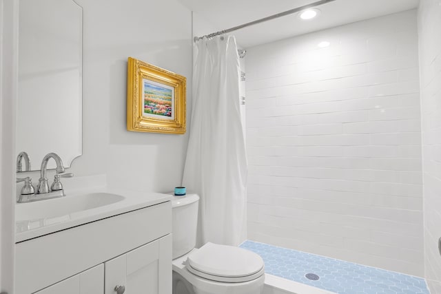 bathroom featuring recessed lighting, vanity, a tile shower, and toilet