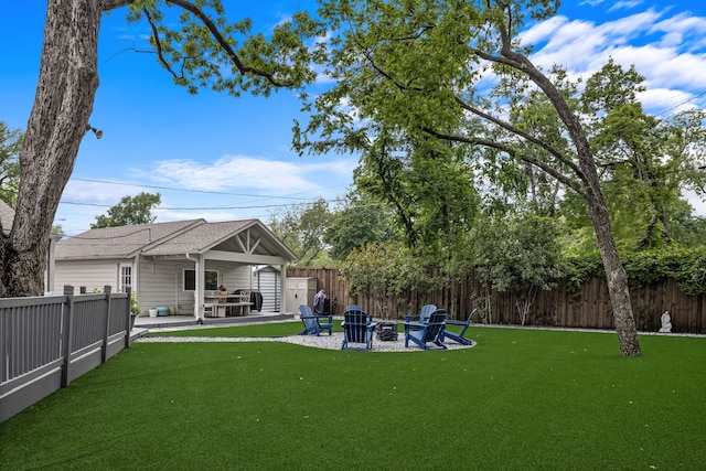 view of yard with a patio, a fenced backyard, and an outdoor fire pit