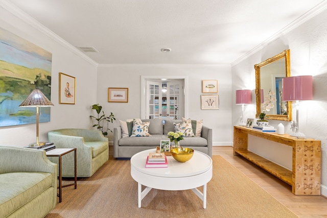 living area with visible vents, ornamental molding, and wood finished floors