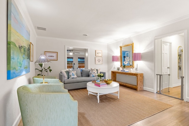 living room featuring ceiling fan, ornamental molding, wood finished floors, and visible vents
