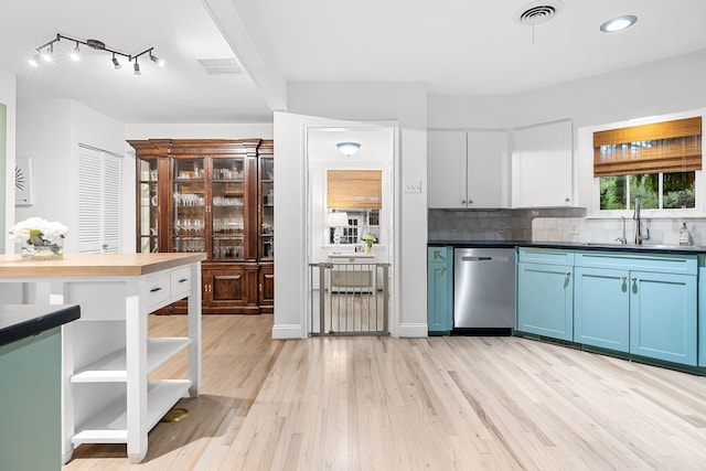 kitchen featuring light wood finished floors, backsplash, stainless steel dishwasher, visible vents, and blue cabinets