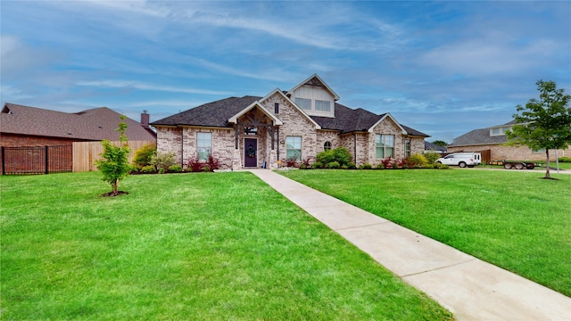 view of front of property featuring brick siding, fence, and a front yard