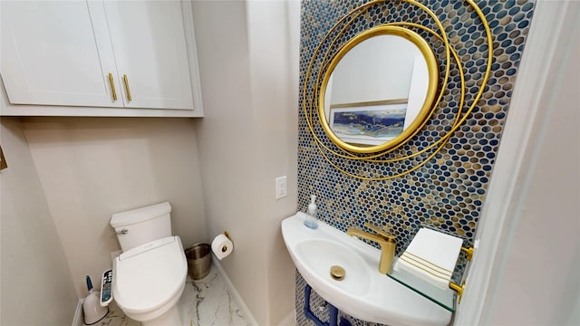 bathroom featuring baseboards, toilet, and marble finish floor