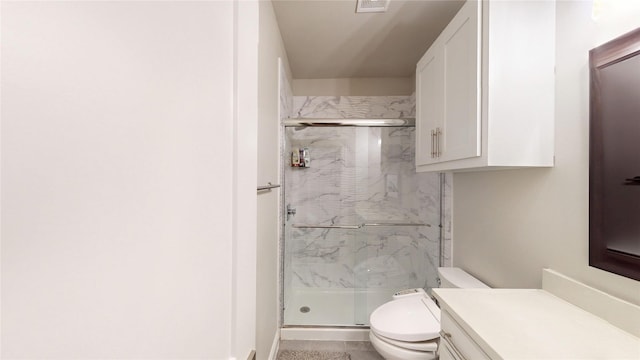 bathroom featuring vanity, a marble finish shower, and toilet