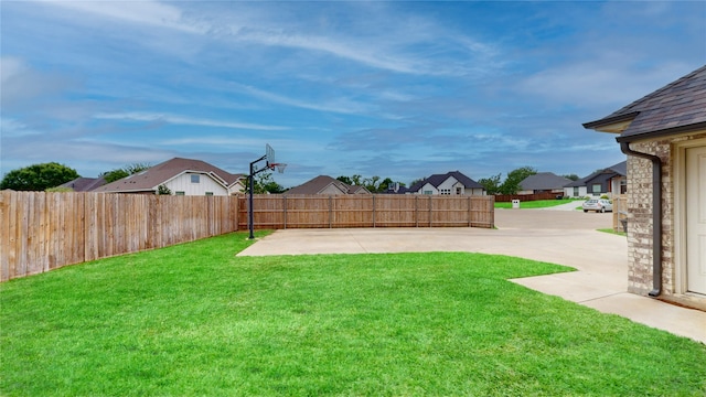 view of yard with a patio, a fenced backyard, and a residential view