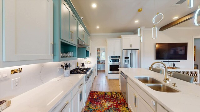 kitchen with a sink, ornamental molding, stainless steel appliances, recessed lighting, and pendant lighting