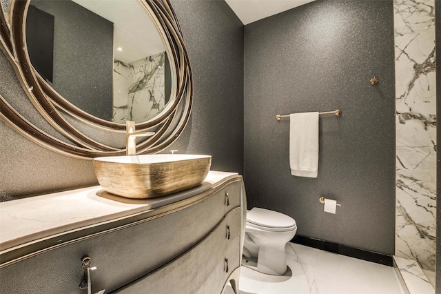 3111 Welborn St Unit 1703, Dallas, TX 75219 - bathroom featuring vanity, toilet, and marble finish floor