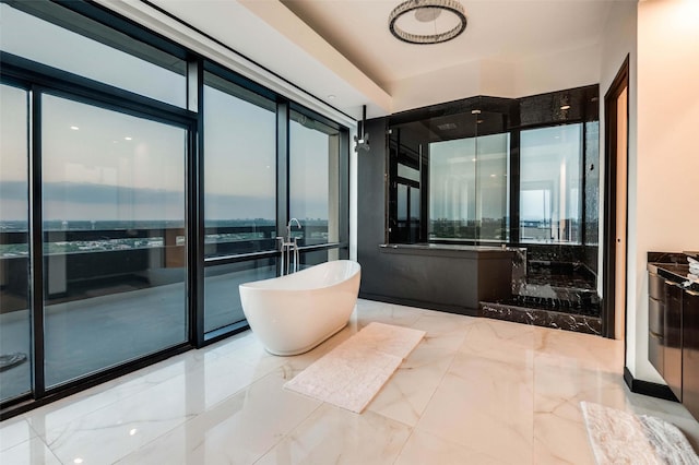 3111 Welborn St Unit 1703, Dallas, TX 75219 - bathroom featuring marble finish floor, a freestanding bath, and a wealth of natural light