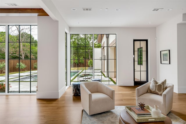 doorway with visible vents, a wealth of natural light, and wood finished floors