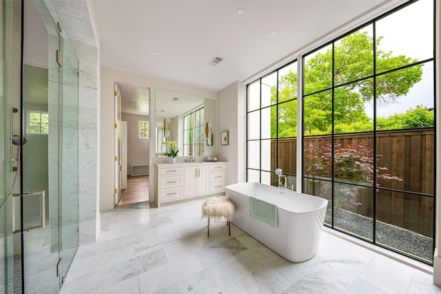 full bathroom with visible vents, vanity, marble finish floor, a soaking tub, and a stall shower