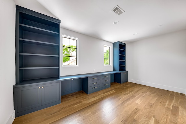 unfurnished office featuring visible vents, built in study area, light wood finished floors, and baseboards