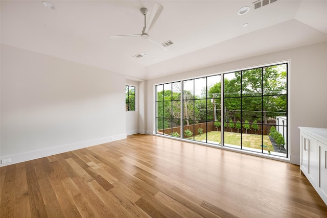 empty room with baseboards, ceiling fan, light wood finished floors, and visible vents