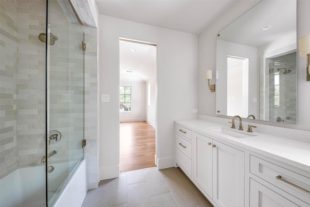 full bath with tile patterned flooring, baseboards, combined bath / shower with glass door, and vanity
