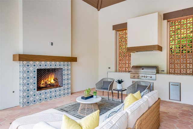 tiled living area featuring high vaulted ceiling and a fireplace