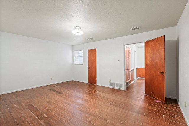1733 Ransom Ter, Fort Worth, TX 76112 - unfurnished room featuring visible vents, baseboards, a textured ceiling, and wood finished floors