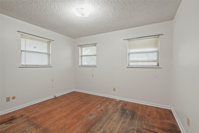 1733 Ransom Ter, Fort Worth, TX 76112 - unfurnished room with wood-type flooring, a textured ceiling, and baseboards