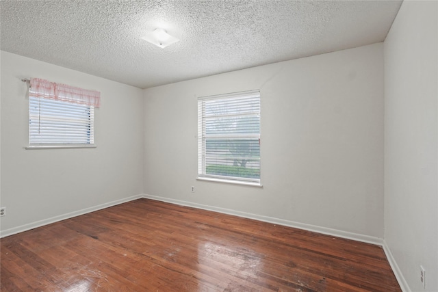1733 Ransom Ter, Fort Worth, TX 76112 - unfurnished room with wood-type flooring, a textured ceiling, baseboards, and a healthy amount of sunlight