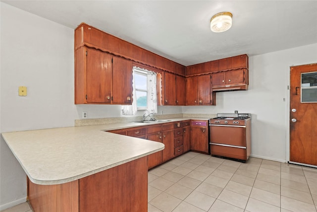 1733 Ransom Ter, Fort Worth, TX 76112 - kitchen with brown cabinets, light countertops, a sink, a peninsula, and gas range oven