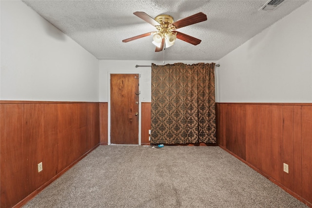 1733 Ransom Ter, Fort Worth, TX 76112 - additional living space featuring visible vents, wainscoting, ceiling fan, wooden walls, and a textured ceiling