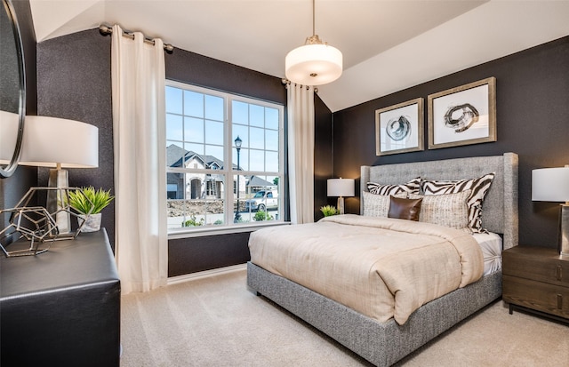 carpeted bedroom with baseboards and lofted ceiling