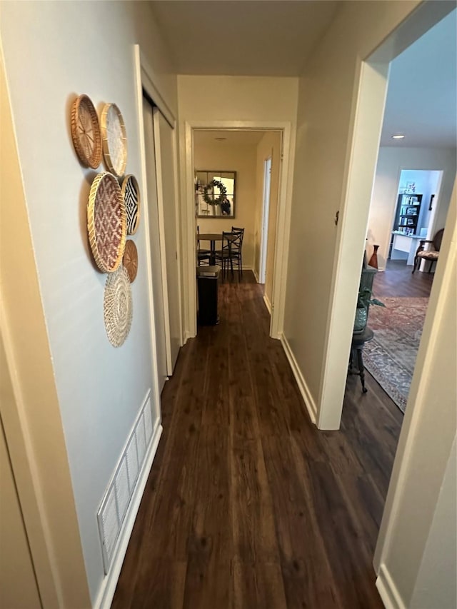 1346 Hillcrest Dr, Graham, TX 76450 - hallway with baseboards, dark wood-type flooring, and visible vents