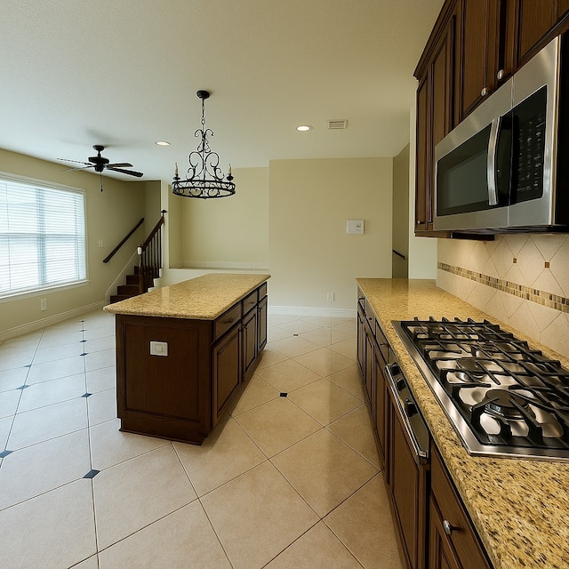 4605 Stargazer Dr, Plano, TX 75024 - kitchen with visible vents, dark brown cabinetry, a center island, tasteful backsplash, and stainless steel appliances