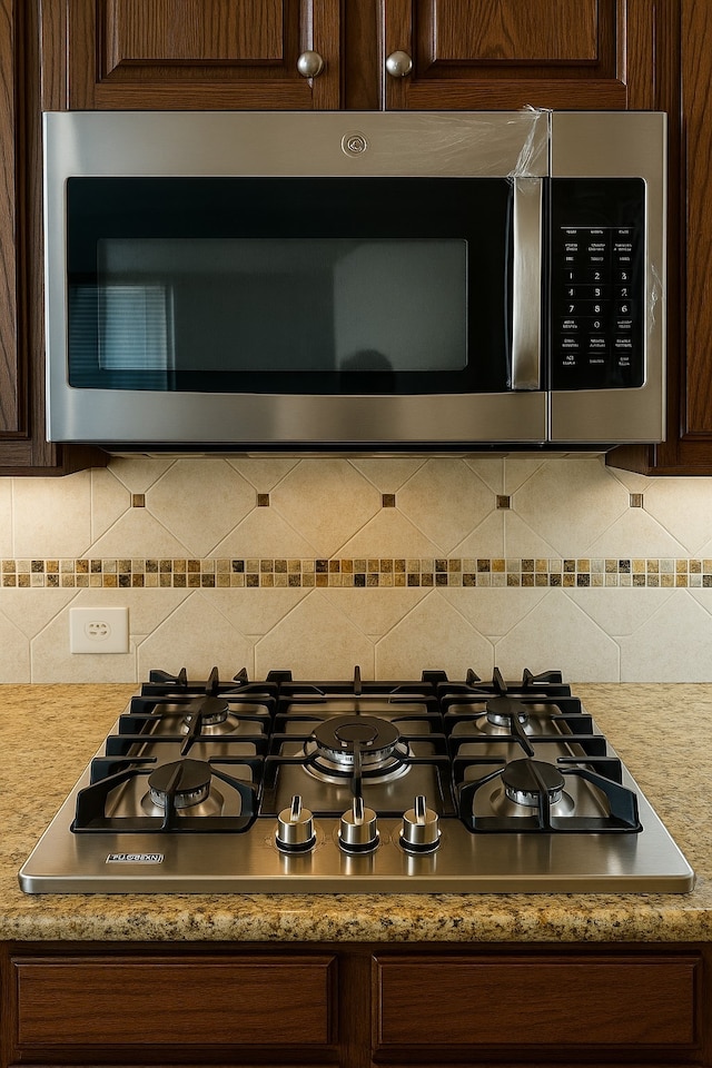 4605 Stargazer Dr, Plano, TX 75024 - details with light countertops, appliances with stainless steel finishes, decorative backsplash, and dark brown cabinets