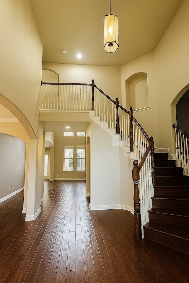4605 Stargazer Dr, Plano, TX 75024 - foyer entrance with a towering ceiling, arched walkways, stairs, and hardwood / wood-style floors