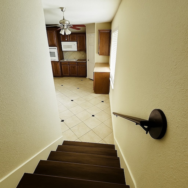 4605 Stargazer Dr, Plano, TX 75024 - stairway with baseboards, a textured wall, ceiling fan, and tile patterned floors