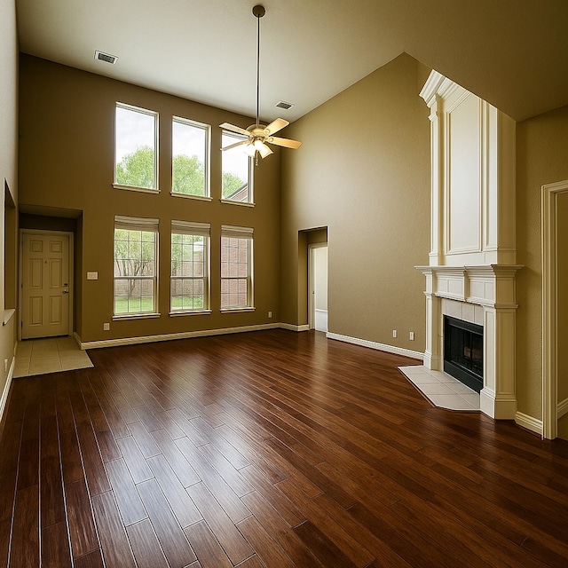4605 Stargazer Dr, Plano, TX 75024 - unfurnished living room featuring ceiling fan, baseboards, wood finished floors, a tile fireplace, and visible vents
