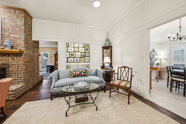 living area with plenty of natural light, a decorative wall, a notable chandelier, and wood finished floors