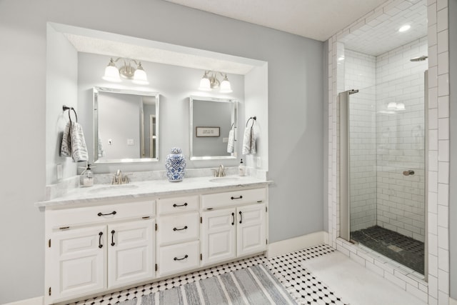 bathroom with double vanity, a sink, and a stall shower