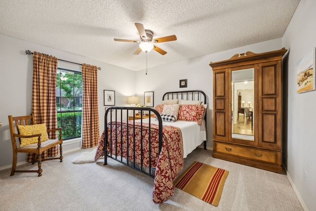 bedroom with baseboards, light carpet, and a textured ceiling