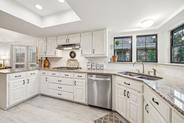 kitchen with backsplash, appliances with stainless steel finishes, a sink, a peninsula, and under cabinet range hood