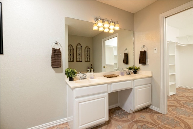 3130 Cimmaron Rd, Weatherford, TX 76087 - bathroom with double vanity, a walk in closet, tile patterned flooring, and baseboards