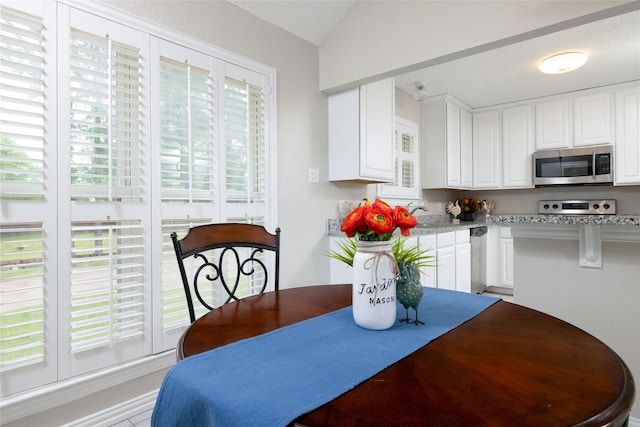 dining space featuring vaulted ceiling