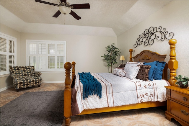 bedroom featuring a ceiling fan, a textured ceiling, vaulted ceiling, and tile patterned flooring