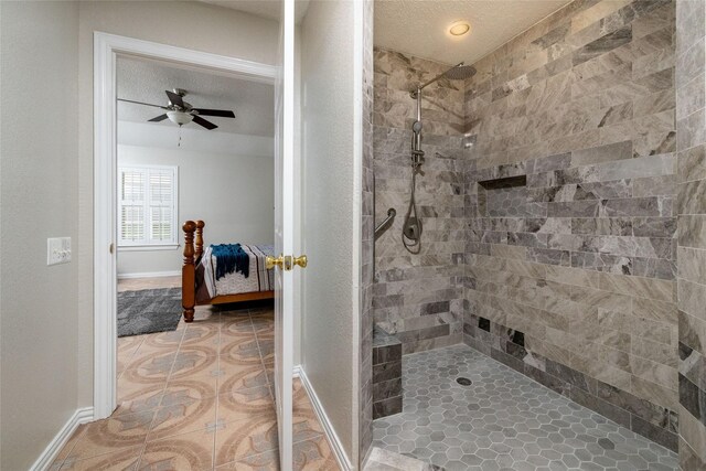 ensuite bathroom featuring a ceiling fan, baseboards, a tile shower, and tile patterned flooring