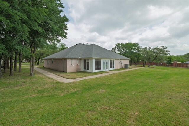 rear view of property with brick siding and a yard