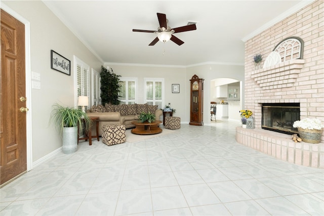 tiled living room with baseboards, a ceiling fan, arched walkways, and ornamental molding