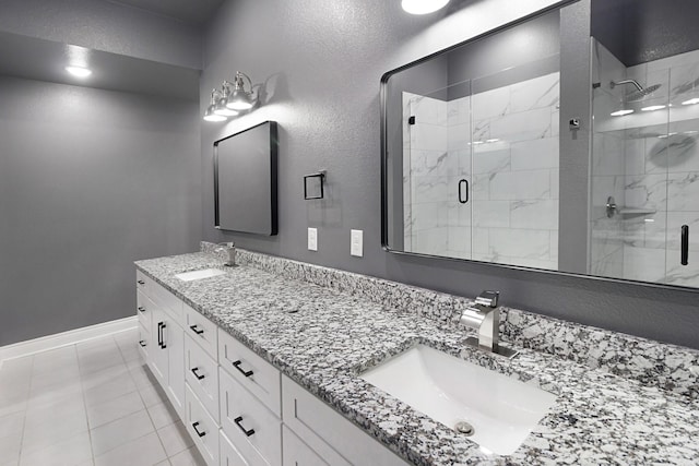 full bath featuring a sink, baseboards, a shower stall, and double vanity