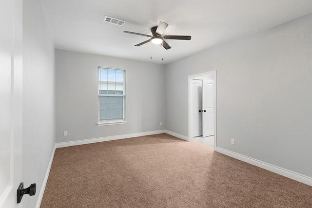 empty room featuring baseboards, ceiling fan, light carpet, and visible vents