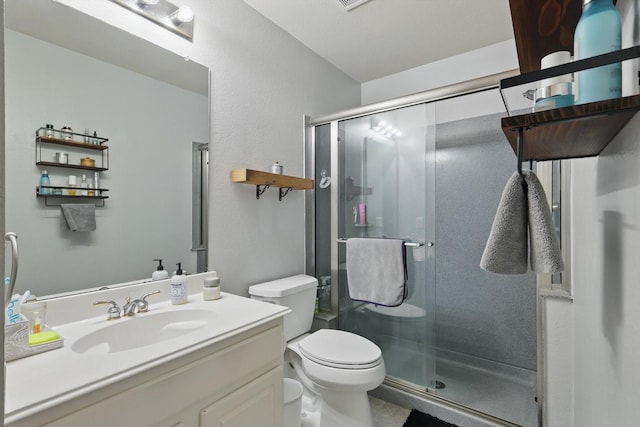 bathroom featuring vanity, a stall shower, and toilet
